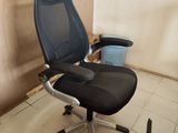 a black office chair sitting next to a window in a room