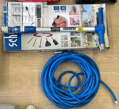 un tuyau bleu posé par terre à côté d'une caisse à outils