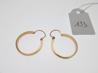 a pair of gold hoop earrings with a price tag