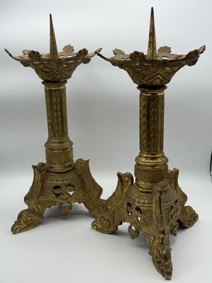 pair of antique brass candlesticks on pedestal with ornate decoration