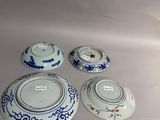 three blue and white bowls and a bowl on a table