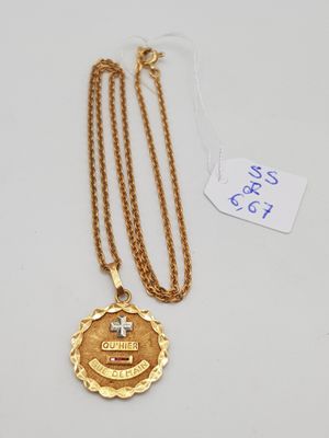 un collier en or orné d'une croix et d'une médaille
