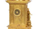 a gold clock that is sitting on top of a table