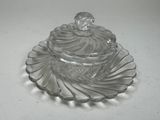 a clear glass container with a lid on a plate