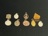 several gold and silver charms on a black surface