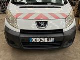 l'avant d'une camionnette blanche garée dans un garage, à côté d'un tas de pneus