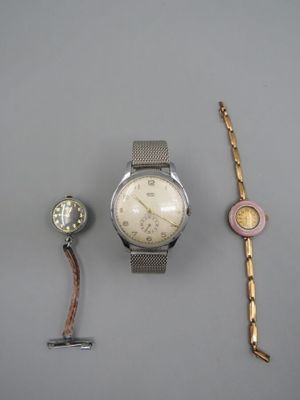 Deux montres et un bracelet sont posés sur une table