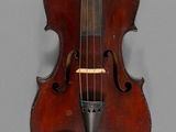 an old violin sitting on top of a table next to a wall