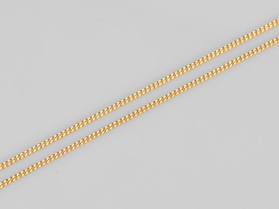 une paire de colliers en chaîne en or sur fond blanc