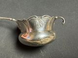 a silver spoon with a handle on a black surface