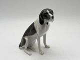 a black and white dog figurine sitting on a white surface