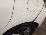 a white car with a hole in the side of it