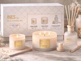 a white box with three candles and a candle holder next to it