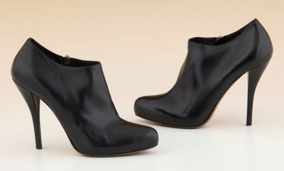 une paire de chaussures à talons hauts noires posées sur une surface blanche