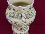 a white vase with a floral design on it on a red background