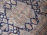a cat that is sitting on a rug on the floor