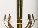 a glass and brass candle holder on a white pedestal
