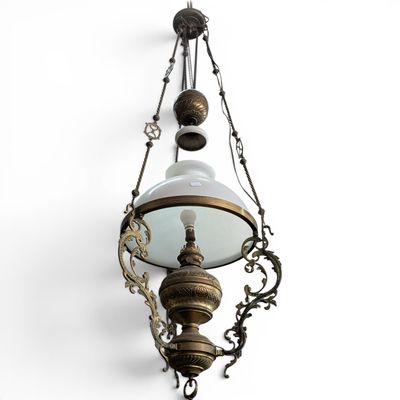 a close up of a light hanging from a chain on a wall