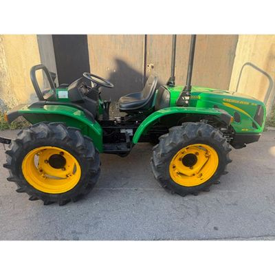 a picture of a green tractor parked in front of a building