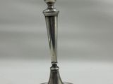 a silver candle holder sitting on a white table