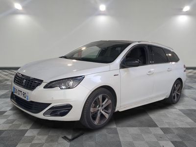 la voiture blanche est garée sur un sol en damier dans le garage