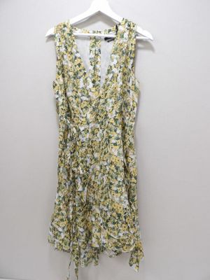 a yellow and white floral dress hanging on a hanger
