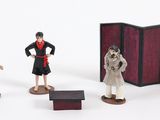 three figurines of people standing next to each other