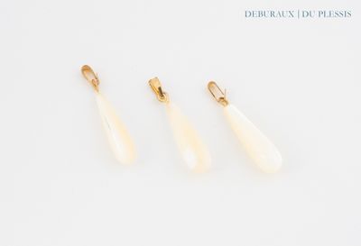 trois paires de boucles d'oreilles dorées et blanches posées sur un fond blanc