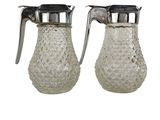 two clear glass pitchers with metal handles on a white background