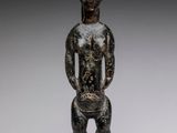 une statue en bronze représentant un homme coiffé d'une tête de chèvre