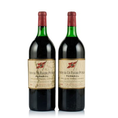 two bottles of red wine sitting next to each other on a white surface