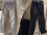 Plusieurs paires de jeans sont empilées sur des cartons dans un entrepôt