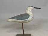 un petit oiseau posé sur un socle en bois
