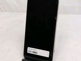 a black cell phone sitting on a stand on a table