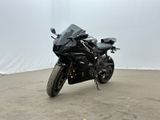une moto noire garée dans une grande pièce