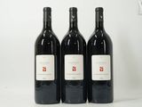 trois bouteilles de vin rouge posées sur une table blanche