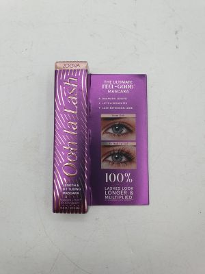 Le mascara se trouve à côté d'une boîte de mascara, posée sur une surface blanche.