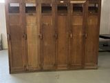 Plusieurs casiers en bois sont alignés dans une grande pièce