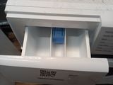 a white dishwasher with a blue handle in a kitchen