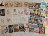 a lot of postcards on a bed with a sheet of paper