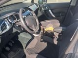 the interior of a car with the door open and a steering wheel in the passenger seat