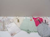 beaucoup de vêtements de bébé posés sur une table