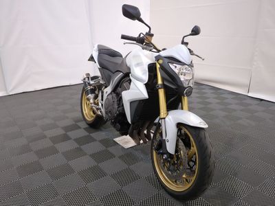 une photo d'une moto blanche et noire garée sur un sol à damier noir et blanc