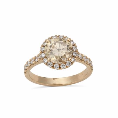 une bague de fiançailles en or jaune sertie d'un diamant ovale de couleur champagne, entouré de diamants blancs