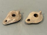 two pieces of pottery sitting on top of a table next to each other