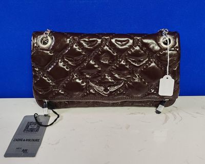 un porte-monnaie en cuir marron muni d'une étiquette, posé sur une table
