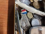a metal container filled with coins and a toothbrush