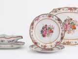 trois assiettes, une tasse et une soucoupe posées sur une table blanche