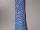 a close up of a tie on a table next to a cup of coffee