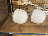 deux lampes blanches posées sur une étagère à l'intérieur d'une cage